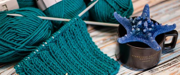 En påbörjad stickning och en kaffekopp.