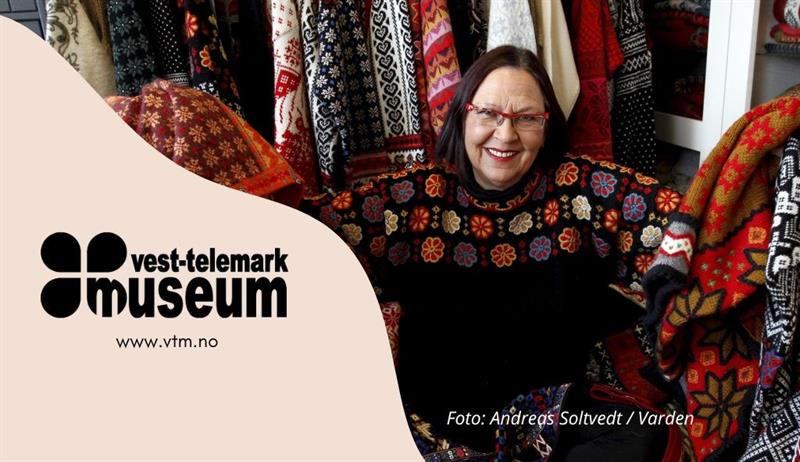 Strikkedesignar Irene Haugland omgjeve av fargerike plagg. Utstilling Vest-Telemark museum Eidsborg.