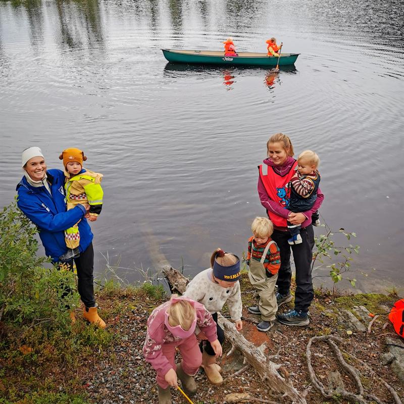 Bilde av voksne og barn ved et vann