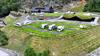 Bubilar på campingplassen ved Lothepus Camping i Odda, med stavkyrkje, langhus og vikinghytter med torvtak