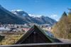 Utsikt frå hytte på Lothepus Camping mot Sørfjorden, Odda sentrum og snøkledde fjell i Hardanger på ein klar vårdag