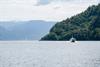 Pilagutt cruising through the Hardangerfjord with majestic mountains in the background.