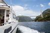Pilagutt sailing under a bridge in the Hardangerfjord.