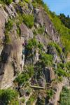 Gruppe klatrar via ferrata-ruta ved Valhall i Odda, med hengebruke og jernstiftar festa i berget.