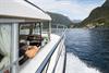 The captain of Pilagutt enjoys the view as the boat cruises through the Hardangerfjord – a relaxing and scenic journey.