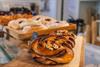 Cinnamon buns in front and other baked goods in the background.