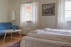 Eit dobbeltrom med ein blå sofa i hjørnet.