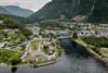 Eit dronebilete av campingplassen med bygda og fjella i bakgrunnen.