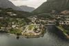 Eit dronebilete av campingplassen med bygda og fjella i bakgrunnen.