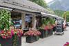 The entrance to the cafe with lots of flowers in front.