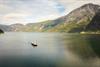 Ein Drohnenfoto des Norled-Bootes draußen auf dem Fjord zwischen hohen Bergen.