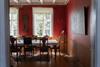 Rotes Zimmer mit langer Tafel, geschnitzten Stühlen und Kronleuchter im Haupthaus von Halsnøy Kloster.