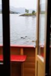 utsikt til fjorden fra ei av hyttene, nokre ender søm på fjorden